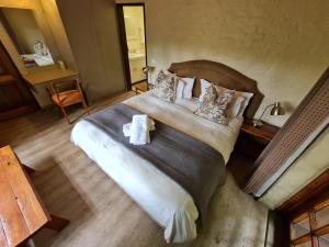 a bedroom with a large bed with towels on it at Migrate Portfolio in Dullstroom