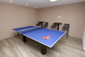 eine Tischtennisplatte in einem Zimmer mit Stühlen in der Unterkunft Apartments Vlasic in Podstrana