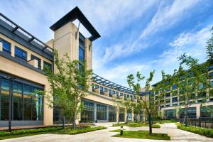 an office building with trees in front of it at Q-Box Hotel Shanghai Sanjiagang -Offer Pudong International Airport and Disney shuttle in Shanghai