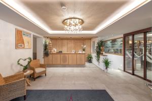an office lobby with a chandelier and a counter at Hotel Theiner in Curon Venosta