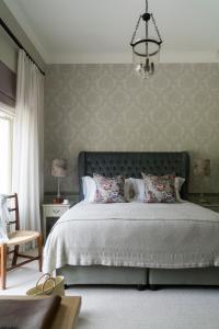 a bedroom with a large bed and a chandelier at Cape Vue Country House in Franschhoek