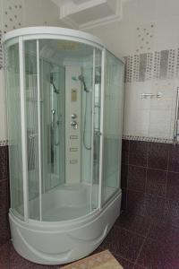 a shower with a glass enclosure in a bathroom at Versal Hotel in Maykop