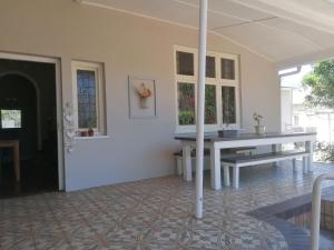 a white room with a table and a bench at Villa de Karoo Guest House in Oudtshoorn