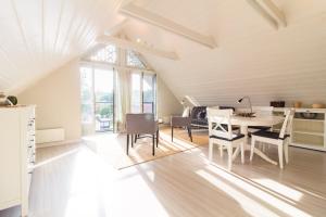 a kitchen and dining room with a table and chairs at Sleepy Eye Apartment, By Cohost in Preila