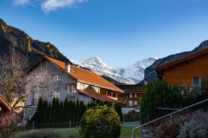 eine Gruppe von Häusern mit Bergen im Hintergrund in der Unterkunft Swiss Holiday House in Wilderswil