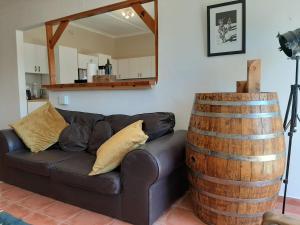 a living room with a black couch and a barrel at Japie's Yard Self-Catering in Swakopmund