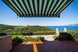 a patio with a roof with a view of the ocean at Appartamenti Vista Mare - Goelba in Capoliveri