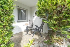 a patio with a table and chairs and a tree at Krokus in Fischen