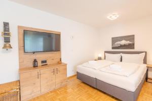 a bedroom with a large bed and a flat screen tv at Krokus in Fischen