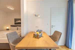a room with a wooden table and chairs and a bed at Krokus in Fischen +1 photo