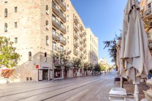 an empty street with an umbrella and a building at Stay Jaffa Jerusalem in Jerusalem