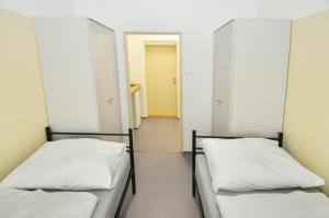 two beds in a room with a hallway at Hostel Tereza Břeclav in Břeclav