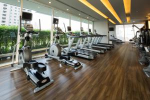 a gym with a row of treadmills and elliptical machines at Ariva Ivy Servizio Thonglor in Bangkok