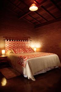 a bedroom with a bed in a brick wall at Pousada Refugio do Serrano in São Bento do Sapucaí