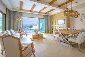 salon ze stołem jadalnym i widokiem na ocean w obiekcie Luxury Villa Prova1 w mieście Malinska