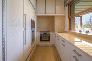 Una cocina con gabinetes blancos y una ventana grande. en Luxury Villa Prova1, en Malinska 41 fotos más
