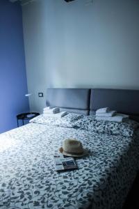 un letto con un cappello e una rivista sopra di LuccaStay 99 a Lucca