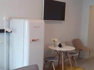 a white refrigerator and a table in a room at Porto Beach Rooms in Porto
