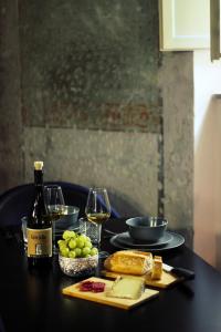 un tavolo con una bottiglia di vino, formaggio e bicchieri da vino di LuccaStay 99 a Lucca