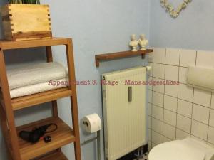 a bathroom with a toilet and a toilet paper dispenser at City-Ferienwohnungen-Dresden - zentral gelegen im Haus Louisenstrasse 11 - Dresden-Neustadt in Dresden