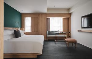 a hotel room with a bed and a chair at Kimpton Da An Taipei- an IHG Hotel in Taipei