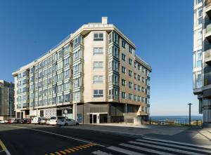 ein großes Gebäude an der Straßenseite in der Unterkunft TH Apartments by Como en Casa in A Coruña
