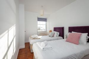 a bedroom with two beds and a window at Shore House, Stunning Sea Views, Parking in Pittenweem