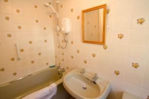 a bathroom with a sink and a tub and a mirror at Langstrath, Chapel Stile in Chapel Stile