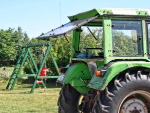 a green tractor parked in a field with a swing at Petersen Uwe in Großenwiehe