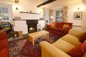 a living room with two couches and a fireplace at Woodland Crag Cottage, Grasmere in Grasmere