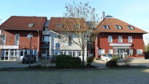 two buildings on a street with cars parked in front at Gasthof Altes Rathaus garni in Rust