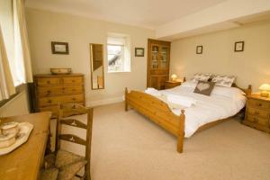a bedroom with a large bed and a dresser at Juniper Grasmere - Juniper Cottage, Grasmere in Grasmere