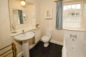 a bathroom with a sink and a toilet and a tub at Juniper Grasmere - Juniper Cottage, Grasmere in Grasmere