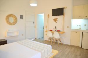 アダマスにあるMargaritari Studios Milosのベッドルーム1室(ベッド1台、テーブル、椅子付)