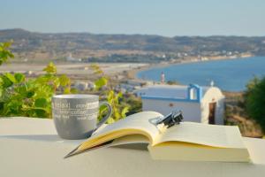 a book and a cup of coffee on a table at Margaritari Studios Milos in Adamantas