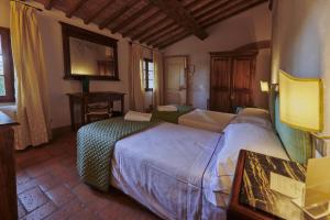 a bedroom with a bed and a dresser at Villa Curina Resort in Castelnuovo Berardenga