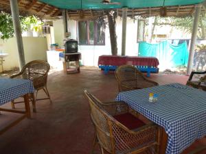 a dining room with tables and chairs and a television at Hotel Thushara in Kovalam
