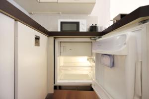 Yourbanflat Butterfly في بادوفا: ثلاجة فارغة وبابها مفتوح في مطبخ