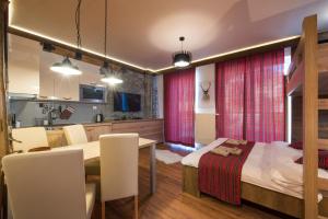 a room with a bed and a table and chairs at 4Roses Apartments in Smokovce