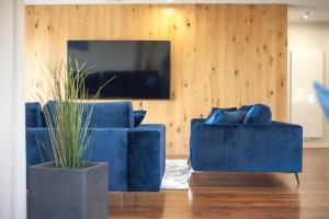 uma sala de estar com um sofá azul e uma televisão em Willa pod Lanckoroną em Izdebnik