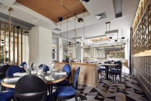 a restaurant with tables and chairs and a bar at Hotel Apis in Kraków