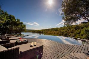 una piscina con mesas y sillas en una terraza de madera en Lalibela Game Reserve - Kichaka Lodge, en Paterson