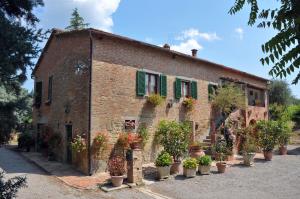a building with potted plants in front of it at Casale Le Capanne in Cortona