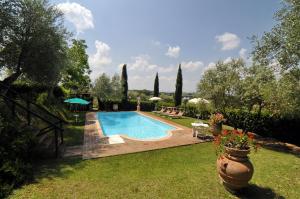 a swimming pool in the yard of a house at Casale Le Capanne in Cortona
