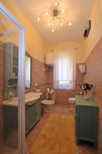 a bathroom with a sink and a toilet and a mirror at Casale Le Capanne in Cortona