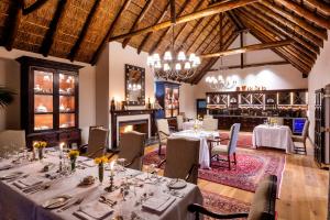 a dining room with tables and chairs and a fireplace at Lalibela Game Reserve - Kichaka Lodge in Paterson
