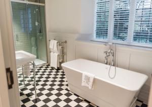 
a white bath tub sitting next to a white toilet at Edgbaston Park Hotel Birmingham in Birmingham
