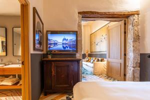 a hotel room with a television and a bed at Hotel La Torre del Canonigo - Small Luxury Hotels in Ibiza Town