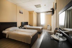 a hotel room with two beds and a table at Hotel Continent in Tobolsk
