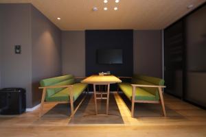 大阪市にある5 minutes 新大阪 9のテーブル、椅子2脚、テレビが備わる客室です。